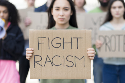 front-view-woman-holding-fight-racism-quote